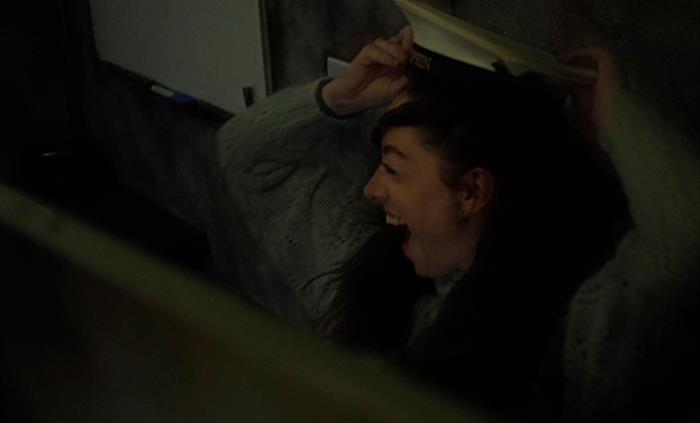 A girl is pictured inside an escape room having just found the captains hat, placing it on her head.